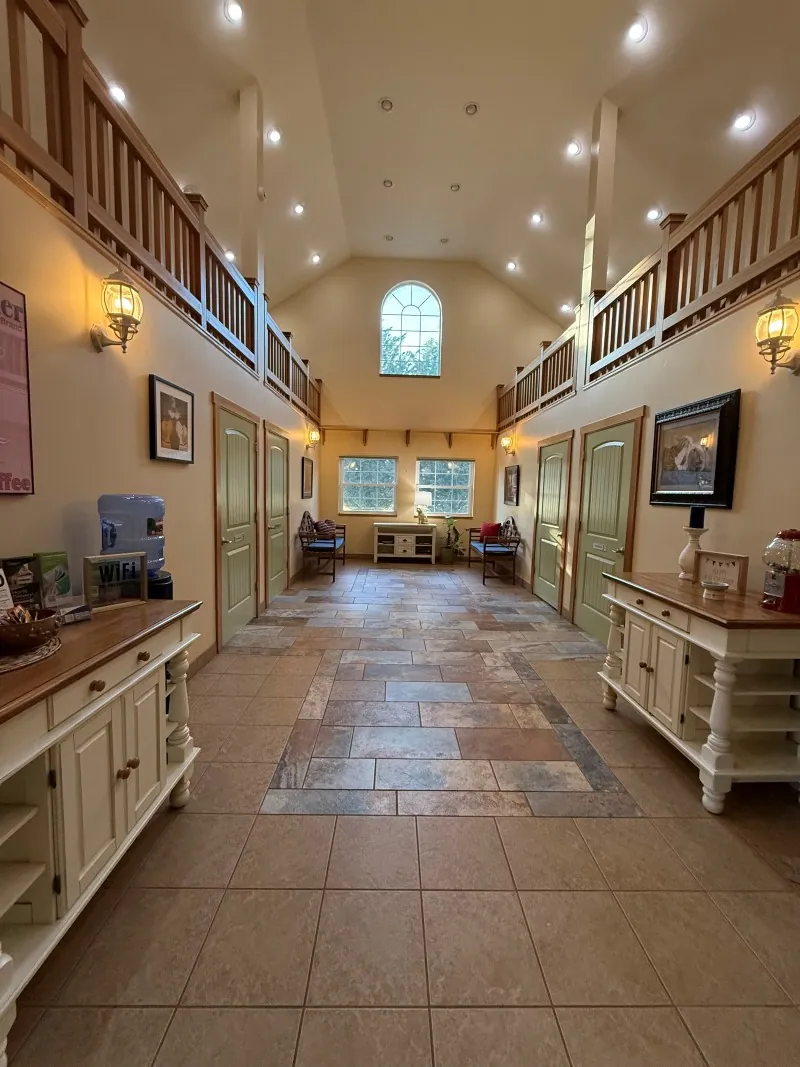 The clinic's main hall with a high barn ceiling and a loft rail