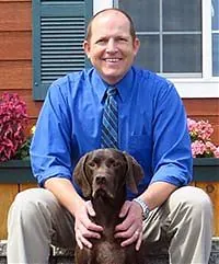 Dr. Justin Vaughn with his chocolate Lab